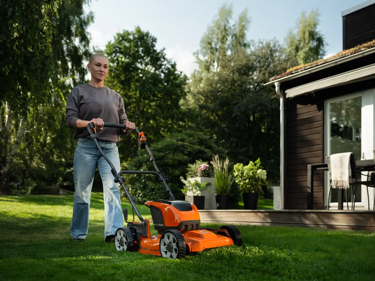 Person som går med gressklipper